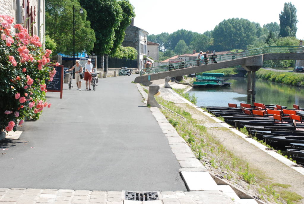 Touristes se promenant sur les quais Louis Tardy le long de la Sèvre niortaise à Coulon